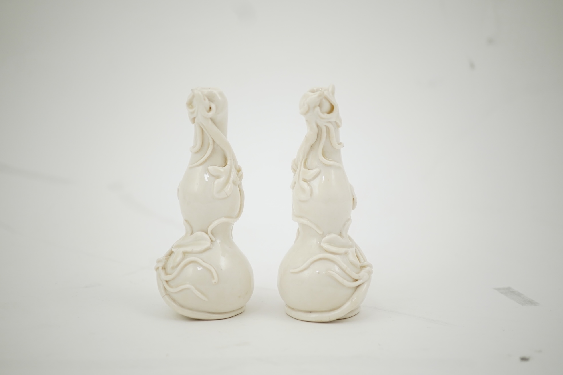 A pair of Chinese blanc-de-chine gourd-shaped vases, Dehua kilns, Qing dynasty